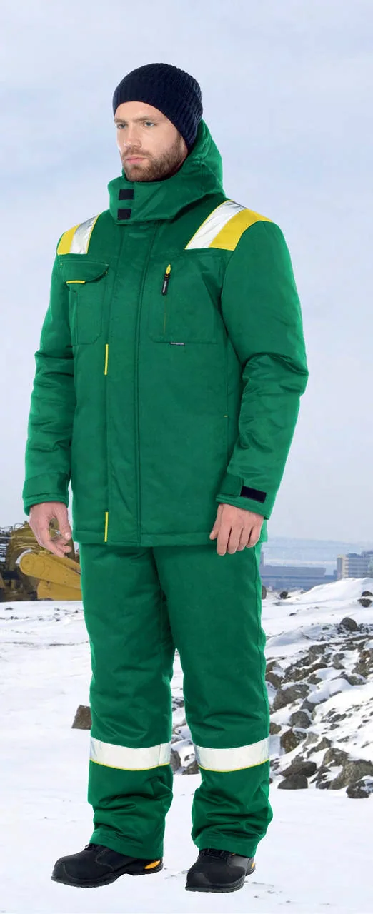 Man wearing a green insulated work suit with reflective strips in a snowy industrial setting